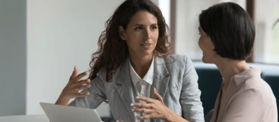 Two colleagues engaged in one-on-one conversation, reflecting healthy interpersonal dynamics and trust in a team setting